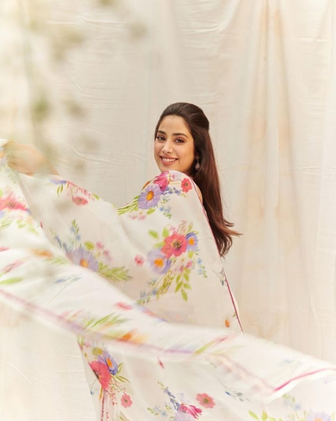 જાન્હવી કપૂર આ ફોટોમાં ફ્લોરલ પ્રિન્ટવાળી જોર્જેટ ઓફ વ્હાઇટ સાડીમાં સિમ્પલ અને કુલ લાગી રહી છે. સ્માઇલી ફેસ અને ઓપન હેર સાથેનો આ પોઝ ફેન્સને ઘણો પસંદ આવી રહ્યો છે. (Photo: @janhvikapoor/instagram)