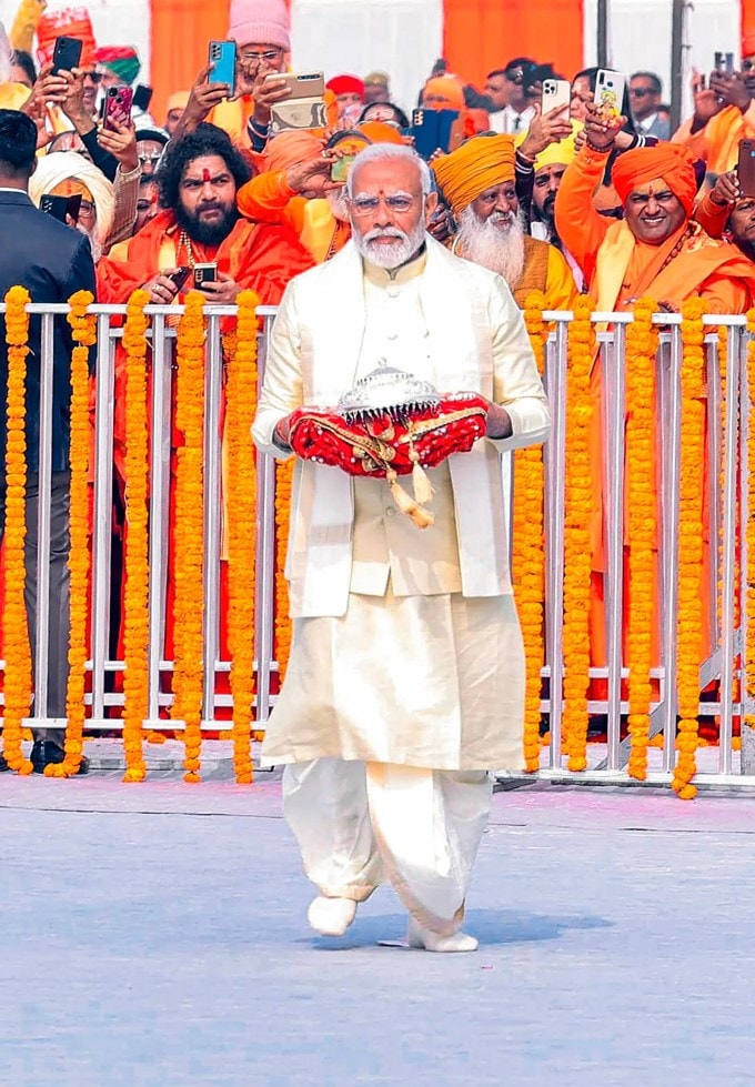 <strong>હાથમાં ચાંદીનું છત્ર લઇ પીએમ મોદી રામ મંદિરમાં પ્રવેશ્યા</strong><br>પીએમ મોદી નવનિર્મિત રામ મંદિરના મુખ્ય દ્વારથી ચાલીને સ્થળ પર પહોંચ્યા અને ગર્ભગૃહમાં પ્રવેશ્યા. આ દરમિયાન પીએમ પોતાના હાથમાં લાલ કપડામાં ચાંદીનું છત્ર લાવ્યા હાતા. (Express Photo)