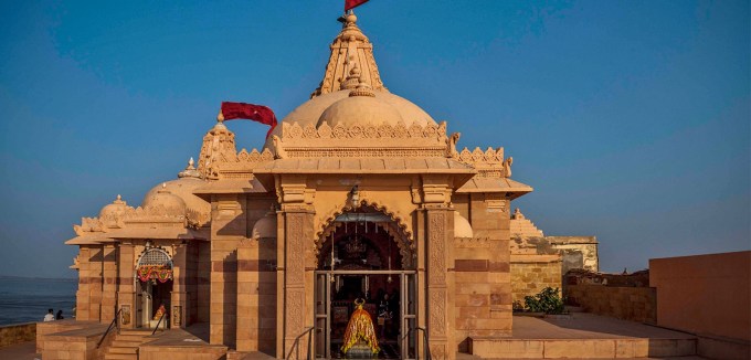 <strong>કોટેશ્વર મહાદેવ મંદિર (Koteshwar Mahadev Temple)</strong><br>કોટેશ્વર મહાદેવ મંદિર કચ્છ જિલ્લાના લખપત તાલુકામાં આવેલું પ્રસિદ્ધ યાત્રાધામ છે. કોટેશ્વર મંદિર કચ્છના રણમાં એક સુંદર અનુભવ કરાવે છે. કોટેશ્વર મંદિરની કથા રાક્ષસ રાજા રાવણ સાથે જોડાયેલી છે. અહીં પ્રવાસીઓ કોટેશ્વર મંદિરમાં દર્શન કરવા ઉપરાંત દરિયા કિનારે બીચ પર ફરવાની, રાતના અંધકારમાં આકાશમાં ચમકતા તાર અને પડોશી દેશ પાકિસ્તાનના કરાચીથી આવતી લાઇટ જોવાનો લાહવો લઇ શકે છે. (Photo: Gujarat Tourism)