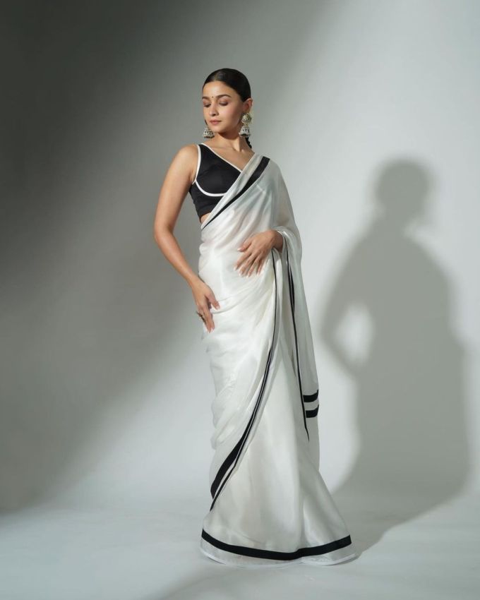 <a href="https://gujarati.indianexpress.com/about/alia-bhatt/" data-type="URL" data-id="https://gujarati.indianexpress.com/about/alia-bhatt/">આલિયા ભટ્ટે</a> આ લુકમાં વાઈટ અને બ્લેક કલરનું પરફેક્ટ બ્લેન્ડીંગ કરીને લુક કંપ્લીટ કર્યો છે. તેની વાઈટ સાડીમાં બ્લેક કલરની બોર્ડર છે, અને બ્લાઉઝ બ્લેક કલરનું જેમાં વાઈટ કલરની ફિનિશિંગ બોર્ડર છે, જવેલરીમાં તેણે હેવી ઓક્સિડાઇઝ્ડ ઝુમકા ઈયરિંગ્સ પહેરી છે અને નાની બ્લેક બિંદી સાથે લુક કંપ્લીટ કર્યો છે. તેણે લાઈટ મેકઅપમાં એલિગન્ટ લાગે છે.