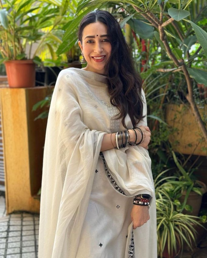 <strong>કરિશ્મા કપૂર સફેદ એમ્બ્રોઇડરી સૂટ (Karishma Kapoor White Embroidered Suit) : </strong>જો તમે પરફેક્ટ લુક મેળવવા માંગતા હો, તો કરિશ્મા કપૂરના મોનોક્રોમેટિક સૂટમાંથી પ્રેરણા લો. તે નેકલાઇનની આસપાસ અને કુર્તા પર નાજુક બ્લેક ભરતકામ સાથે સફેદ આધાર દર્શાવે છે. તમે પ્રિન્ટેડ અને એમ્બ્રોઇડરીવાળા પહોળા-પગવાળા, હાઈ વેસ્ટ પેન્ટ સાથે જોડીને આઉટફિટ લુક કમ્પ્લીટ કર્યો છો. સફેદ દુપટ્ટા, ઓક્સિડાઇઝ્ડ ઝુમકા અને બ્લેક બંગડીઓ વડે લુક કંપ્લીટ કરે છે. 