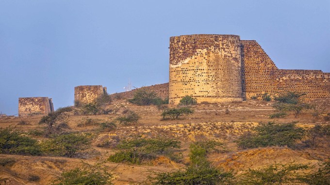 <strong>Lakhpat Fort : લખપત કિલ્લો</strong><br>લખપત કિલ્લો નારાયણ સરોવરની ઉત્તરે માત્ર 33 કિમી દૂર આવેલું ઐતિહાસિક સ્થળ છે. 18મી સદીમાં આ શહેર એક મહત્વપૂર્ણ દરિયાઇ વેપાર નોડ હતું. કોરી ખાડીના મુખ પર, કિલ્લાની વિશાળ દિવાલો હજુ પણ ટૂંકા પરંતુ ભવ્ય ભૂતકાળની સાક્ષી આપે છે. તમે કિલ્લાના રેમ્પાર્ટ પર ચઢી શકો છો, જે કિલ્લાનું એકમાત્ર બાકી માળખું છે, અને શાંત સમુદ્રને જોઈ શકાય છે. આ સ્થળ ખાસ કરીને સૂર્યાસ્ત સમયે અદભૂત હોય છે. કિલ્લાની દિવાલોની અંદર, 16મી સદીનો ગુરુદ્વારા પણ આવેલું છે. એવું માનવામાં આવે છે કે ગુરુ નાનક તેમની યાત્રા દરમિયાન બે વાર અહીં રોકાયા હતા. (Photo: Gujarat Tourism)