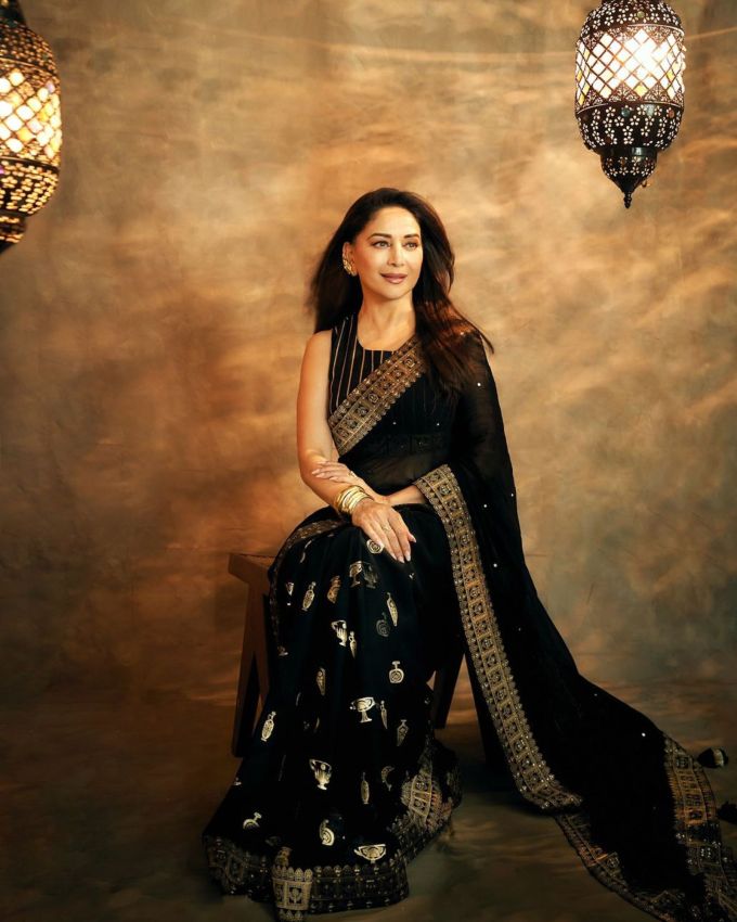 <strong>માધુરી દીક્ષિત હેરસ્ટાઇલ :</strong> બ્લેક સાડીમાં એકટ્રેસે સ્ટ્રેટ હેર સાથે એક્સેસરીઝને ચમકાવે છે. તેણે તેના વાળની ​​એક બાજુ પાછળ રાખી પાર્ટીશનમાં સ્ટાઈલ કર્યા છે.