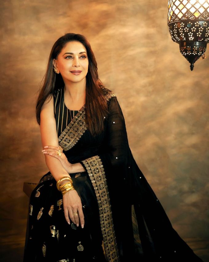 <strong>માધુરી દીક્ષિત મેકઅપ અને જવેલરી : </strong>આઉટફિટ ઉપરાંત માધુરી દીક્ષિતનો મેકઅપ અને એસેસરીઝ પણ જોવા લાયક હતા. તેના આઉટફિટની જેમ જ, તેના મેકઅપમાં તમામ ગ્લેમ વાઇબ્સ આવે છે. તેણે ગોલ્ડન આઈશેડો, બોલ્ડ બ્લેક આઈલાઈનર અને ડીફાઈંડ આઈબ્રોઝ સાથે તેના લુકને નેક્સ લેવલ કર લઇ જાય છે. ચળકતા ગાલ અને મિનિમલ ન્યૂડ લિપસ્ટિક તેના ચહેરાના વધુ એલિગન્ટ લુક આપે છે.