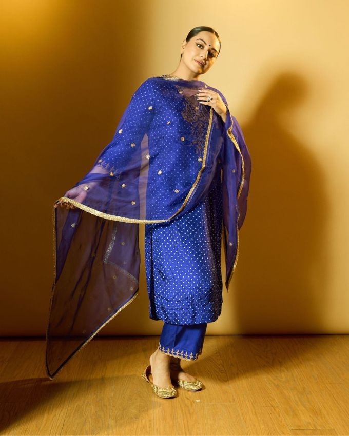 <strong>સોનાક્ષી સિંહા ફેશન </strong>: સોનાક્ષી સિંહા ગોલ્ડન ભરતકામ અને મીડીયમ લેન્થની સ્લીવ્ઝ સાથે હાઈ વી-નેકલાઇન વાળા આઉટફિટ પસંદ કર્યા છે, તે ખુબજ ગ્લેમરસ લાગે છે તેના ડ્રેસની હેમલાઇન ની સુધીની છે. જે તેને લગ્ન અને ફેસ્ટિવલ બેસ્ટ બનાવે છે.એકટ્રેસએ બાંધણી કુર્તાને રોયલ બ્લુ પેન્ટ સાથે પેર કરી છે.જેમાં લુઝ ફિટિંગ પગ અને હેમ પર સોનેરી ભરતકામ જોવા મળે છે, જે એલિગન્ટ લાગે છે. પગની એન્કલ લેન્થના પેન્ટ તેના કુર્તાને સુંદર રીતે પૂરક બનાવે છે.