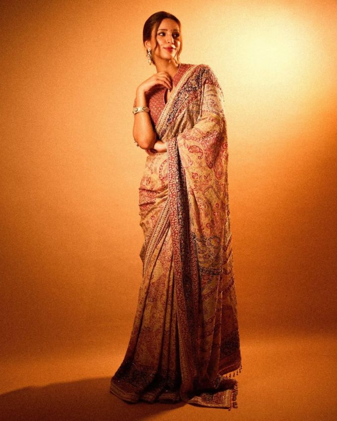 <strong>તૃપ્તિ ડીમરી રેડ સાડી : </strong>તૃપ્તિ ડીમરીએ આમ સિલ્કની બ્લોક પ્રિન્ટેડ સાડી પસંદ કરી છે જેમાં તેણે સોલ્ડર અને બેક કવર બ્લાઉઝ પસંદ કર્યો છે જેમાં ઝીરો શેપ ડિઝાઇન પેટર્ન જોવા મળે છે, જેમાં ડિટેલડ વર્ક જોવા મળે છે. જેમાં હાફ સ્લીવ છે અને એમાં બોર્ડર પર ગ્રીન કલરના ઝુમખા જોવા મળે છે, જવેલરીની વાત કરીયે તો તેણે સિલ્વર લોન્ગ ઝુમખા ઈયરિંગ્સ પસંદ કરી છે, અને એની સાથે બન હેરસ્ટાઇલ સાથે લુક કંપ્લીટ કર્યો છે.