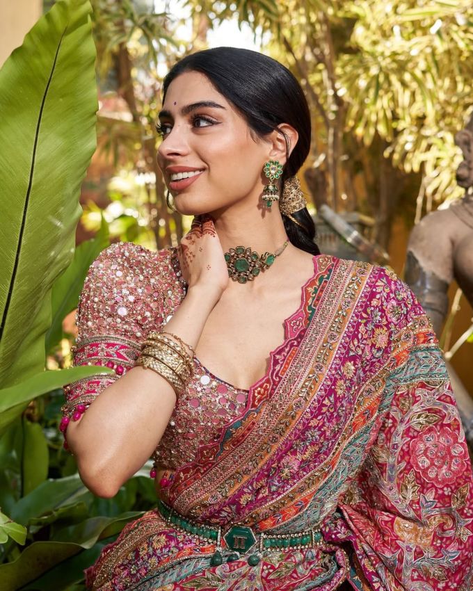 ખુશી કપૂરે સુંદર મલ્ટી-કલર્ડ પશ્મિના સાડીનો ફોટો શેર કર્યો હતો. તેના આઉટફિટની પસંદગીને જોતા તેણે તેના લુકમાં તમામ કલરનો સમાવેશ કરવાનો બેસ્ટ પ્રયાસ છે જે મહેંદી સેરેમની માટે બેસ્ટ ઓપ્શન હોઈ શકે. તેના બ્લાઉઝમાં હાફ-સ્લીવ્ઝ અને કોમ્પ્લેક્સ ડિટેલ્સથી ડેકોરેટેડ એક સ્કૂપ્ડ નેકલાઇન છે, જે તેના લુકમાં ચાર્મ ઉમેરે છે.બ્લાઉઝમાં બેકલેસ ડિઝાઇન ઉપરાંત તેના બ્લાઉઝમાં ટ્રેડિશનલ પેચીસ જોવા મળે છે ટ્રેડિશનલી ડિટેલમાં પેચ દર્શાવવામાં આવ્યા હતા. આ એલિગન્ટ ટચ  ટ્રેડિશનલ બ્લાઉઝને એસ્થેટિક લુક આપે છે.