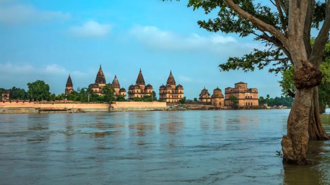 <strong>Famous Places To Visit In Orchha Ram Raja Mandir History: ઓરછા</strong><br>ઓરછા મધ્યપ્રદેશના ટીકમગઢ જિલ્લામાં આવેલું સુંદર ધાર્મિક અને ઐતિહાસિક સ્થળ છે. ઝાંસી થી માત્ર 15 કિમી દૂર આવેલા ઓરછાના રામ રાજા મંદિરનું મહાત્મય અયોધ્યા જેટલું છે. અહીં ભગવાન રામ રાજા તરીકે પૂજાય છે અને 1 દિવસમાં 4 વખત ગાર્ડ ઓફ ઓનર એટલે કે બંદુક વડે સલામી પણ આપવામાં આવે છે. બેતવા નદીના કિનારે આવેલું ઓરછા અદભુત મહેલ, મંદિર અને કુદરતી સૌંદર્યથી ભરપૂર ધાર્મિક અને પ્રવાસન સ્થળ છે. ચાલો જાણીયે ઓરછાના ભવ્ય ઇતિહાસ, રામ રાજાની કહાણી અને જોવાલાયક સ્થળો વિશે વિગતવાર (Photo: Madhya Pradesh Tourism)
