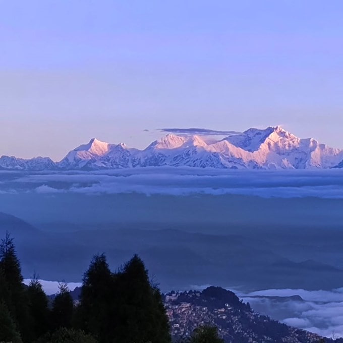 <strong>Darjeeling Tour Plan: દાર્જિલિંગ પ્રવાસ</strong><br>દાર્જિલિંગ પશ્ચિમ બંગાળનું પ્રખ્યાત હિલ સ્ટેશન છે. દાર્જિલિંગને પહાડોની રાણી (Queen of the Hills) કહેવામાં આવે છે. વાદળો સાથે વાતો કરતા બરફાચ્છાદિત હિમાલય પર્વત, ઉંચા લીલાછમ વૃક્ષો, ધુમ્મસો, રંગબેરંગી ફુલોશી સજેલું કુદરતી સૌદર્યથી ભરપૂર દાર્જિલિંગ પ્રવાસીઓને ખેંચી લાવે છે. દાર્જિલિંગમાં શિયાળામાં હિમવર્ષા થાય છે. દાર્જિલિંગમાં સૂર્યોદયનો નજારો માણવા દુનિયાભરના પ્રવાસીઓ આવે છે. (Photo: Social Media)