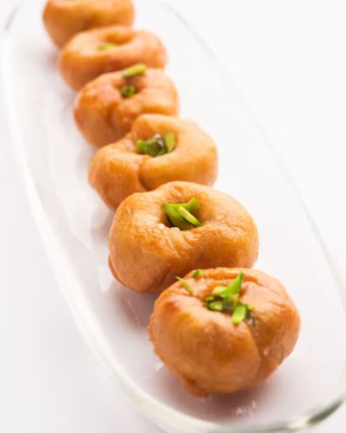 <strong>બાલુશાહી રેસીપી સામગ્રી </strong>: 1 કપ મેંદાનો લોટ, 1/4 કપ (લોટમાં ભેળવવા માટે) બટર, 1/4 ચમચી બેકિંગ સોડા, 1-2 ચમચી દહીં, પાણી - જરૂર મુજબ (લોટ ભેળવવા માટે), તળવા માટે તેલ, ચાસણી માટે: 1કપ ખાંડ, 1/2 કપ પાણી, 1/2 ચમચી ઈલાયચી પાવડર, કેસર (ઓપ્શનલ)