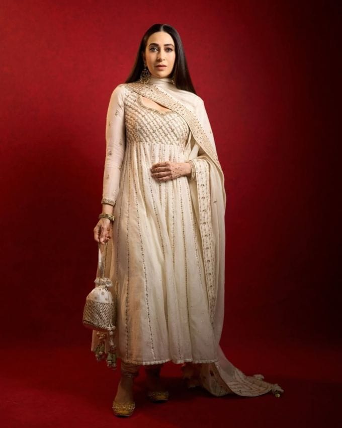 કરિશ્મા કપૂરના આ સફેદ અનારકલી સૂટથી તેણીને રોયલ લુક મળી રહ્યો છે. આ અનારકલી ફુલ સ્લીવ્ઝ અને સ્વીટહાર્ટ નેકલાઇન ધરાવે છે. કરિશ્માના પગમાં ગોલ્ડન જટ્ટી અને એક્સેસરીઝ તરીકે મેચિંગ પોટલી છે. આ ઉપરાંત, કરિશ્માએ તેના ઓપન હેર અને સીધા રાખ્યા છે જે સમગ્ર લુકની સુંદરતામાં વધારો કરી રહ્યા છે. 