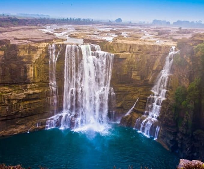 <strong>પુરવા ધોધ, રીવા (Purwa Waterfall)</strong><br>પુરવા ધોધ 200 ફૂટ ઊંચો છે (લગભગ 67 મીટર) અને એક જોરદાર દૃશ્ય રજૂ કરે છે. ધોધ તીવ્ર હોય છે અને દર સેકન્ડે પાણીનો પ્રચંડ જથ્થો પડે છે. ધોધ તોન્સ નદી પર છે, જે રીવા ઉચ્ચપ્રદેશની ભેખડ પરથી ઉતરી રહ્યો છે. ધોધ મોસમ સાથે તેની ભવ્યતા મેળવે છે, જ્યારે વરસાદ પૂરજોશમાં હોય વધુ સુંગર લાગે છે. પૂર્વા ફોલ મુખ્યથી રીવા લગભગ 25 કિમી દૂર છે. (Immage : Madhya Pradesh Tourism)