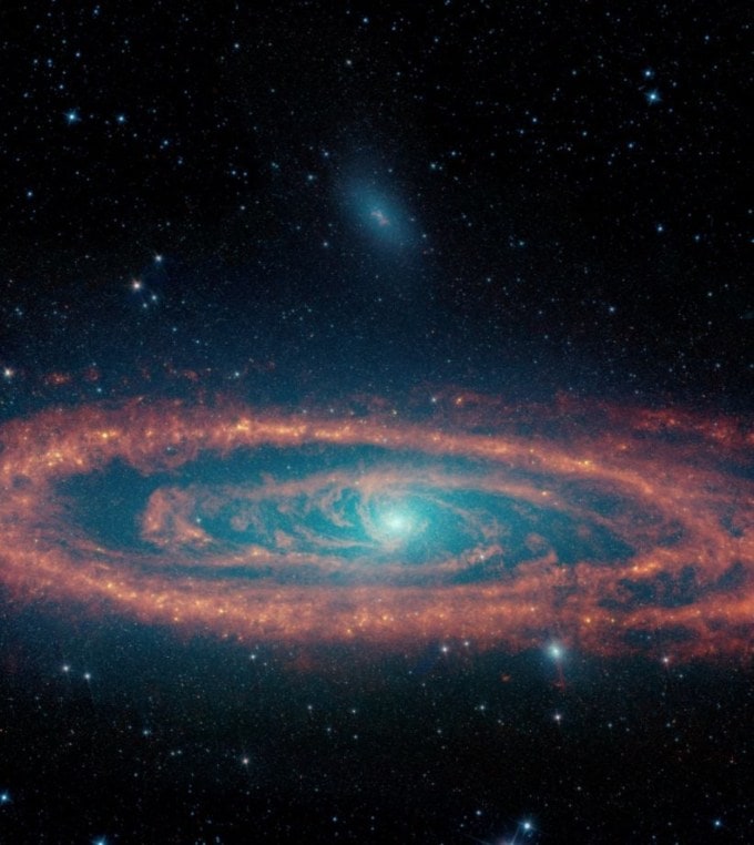 નાસા દ્વારા લેવાયેલ અંતરિક્ષની મનમોહક તસ્વીર.  એન્ડ્રોમેડા ગેલેક્સીની આ છબી નાસાના નિવૃત્ત સ્પિટ્ઝર સ્પેસ ટેલિસ્કોપના ડેટાનો ઉપયોગ કરે છે. બહુવિધ તરંગલંબાઇઓ બતાવવામાં આવી છે, જે તારાઓ (વાદળી અને આછા વાદળી રંગમાં), ધૂળ (લાલ) અને તારા રચનાના ક્ષેત્રો દર્શાવે છે. (ફોટો સ્ત્રોત: Nasa)