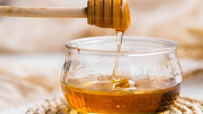 <strong>મધ : Honey</strong><br>મધ નેચરલ સ્વિટનર છે, જે એન્ટિઓક્સિડેન્ટ અને એન્ટિ બેક્ટીરિયલ ગુણોથી ભરપૂર હોય છે. ભારતમાં પ્રાચીન સમયથી મધ ઔષધીય દવા અને ભોજનમાં વપરાય છે. જો કે મધ ગરમ કરીને ખાવાની મનાઇ છે, કારણ કે તેનાથી મધના પૌષક તત્વો નષ્ટ થાય છે. મધનો ઉપયોગ ઠંડી મીઠાઇ જેમ કે હલવો, શકકરપારા કે ફળમાંથી બનતી મીઠાઇમાં મીઠાશ લાવવા માટે કરી શકાય છે. તેનાથી મીઠાઇમાં ખાસ મીઠાસ આવે છે અને પૌષ્ટિક બને છે. (Photo: Freepik)