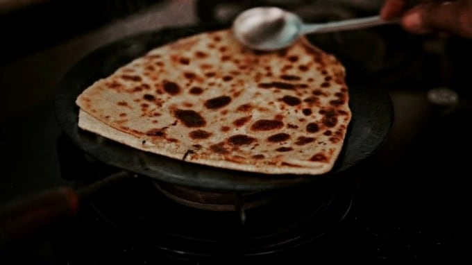 <strong>પરાઠા (Paratha) – રેન્ક 16 | રેટિંગ 4.4</strong><br>ભારતીય નાસ્તાનું ગૌરવ - પરાઠા, પછી ભલે તે બટેટા હોય કે મૂળા-પનીર, ઘરગથ્થુ નામ છે. જોકે અહીં આપણે સાદા પરાઠા વિશે વાત કરી રહ્યા છીએ, જે આખા ઘઉંના લોટમાંથી બનાવવામાં આવે છે, ઘીમાં રાંધેલા હોય છે અને ગોળ, ત્રિકોણાકાર, ચોરસ અથવા સપ્તકોણીય આકારમાં ઉપલબ્ધ હોય છે. તે અથાણું, દહીં અથવા લસ્સી સાથે શ્રેષ્ઠ રીતે ખાવામાં આવે છે. (Photo Source: Unsplash)