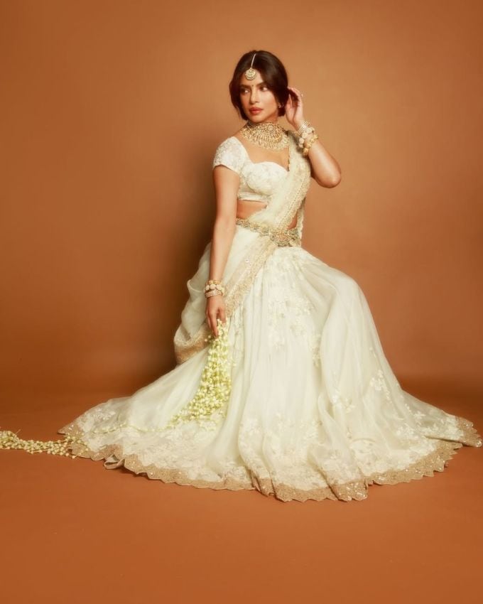 પ્રિયંકા ચોપરા (Priyanka Chopra) લાંબા વિરામ પછી ભારતીય સિનેમામાં પાછી ફરી છે, આ વખતે એસએસ રાજામૌલીની વારાણસી (Varanasi) માં 'મંદાકિની' (Mandakini) તરીકેની ભૂમિકા સાથે. હૈદરાબાદમાં મેગા પ્રોજેક્ટના ફર્સ્ટ લુક રિલીઝ માટે દેશી ગર્લએ હાથીદાંતનો કસ્ટમાઇઝ્ડ અનામિકા ખન્ના લહેંગા પસંદ કર્યો હતો, જેનાથી ઇન્ટરનેટ સ્તબ્ધ થઈ ગયું હતું.