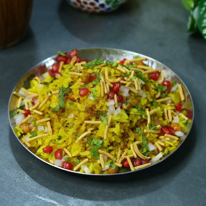 <strong>ઈન્દરી પૌંઆ</strong><br>નાસ્તા માટે ઈન્દોરી પૌંઆ ઉત્તમ વાનગી છે. ઇન્દોરના પ્રખ્યાત પૌઆ તેના સોફ્ટ અને મીઠા સ્વાદ માટે જાણીતા છે. તે થોડી મીઠાશ, સિંગદાણા અને લીંબુનો રસ, ચાટ મસાલા સાથે તૈયાર કરવામાં આવે છે. પૌંઆ ઉપર રતલામી સેવ ઉમેરવાથી વધુ સ્વાદિષ્ટ લાગે છે. (Photo: Social Media)